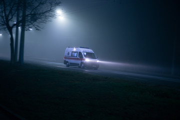Fototapeta na wymiar Ambulance rushes in the fog at night