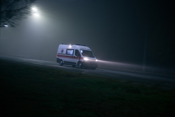 Fototapeta na wymiar Ambulance rushes in the fog at night