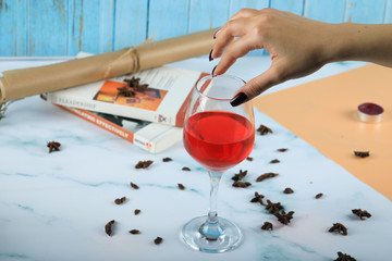Red rose wine in a glass taken by hand of a woman