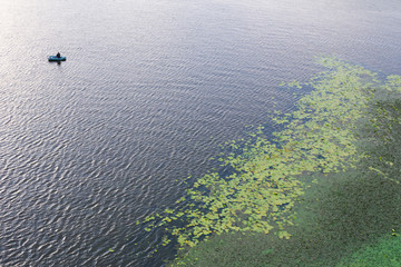 Man in an inflatable boat with a fishing rod in the sea