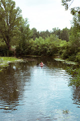 Fototapeta na wymiar A guy and a girl canoe paddling the river