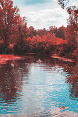 A guy and a girl canoe paddling the river in fall