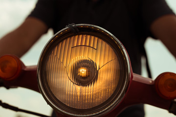Obraz premium Turned on motobike headlight with warm light