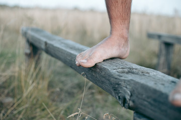 Man barefoot on the log in daylight