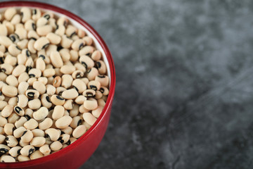 White dry beans in a pink bowl on the left of the background