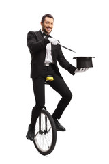Magician on a unicycle performing a hat trick © Ljupco Smokovski
