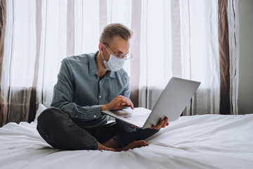 Man freelancer is working with a laptop at home during quarantine. . Remote work concept