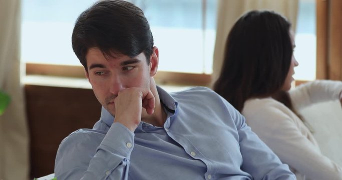 Sad young husband avoiding talk depressed after fight with wife. Upset frustrated man boyfriend tired of family problems, jealousy, feels indifferent. Unhappy couple relationship and conflicts concept
