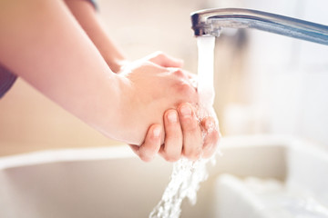 Washing hands under running water using soap, important step for a good hygiene