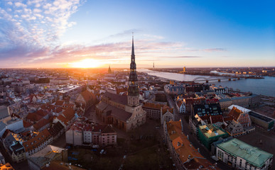 Aerial panoramic view to histirical center Riga, quay of river Daugava. Famous Landmark - st. Peter's Church's tower and City Dome Cathedral church, Old Town Monument. Latvia, Europe. shot from drone.