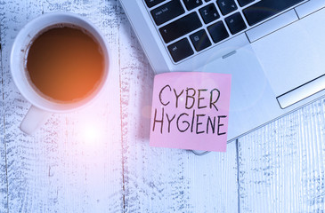 Conceptual hand writing showing Cyber Hygiene. Concept meaning steps that computer users take to improve their cyber security Trendy metallic laptop sticky note coffee cup on vintage table