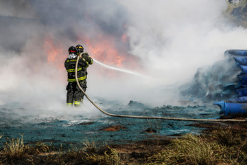 Obraz premium Two firefighters containing the flames