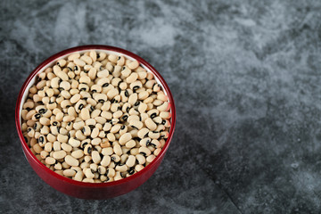 White dry beans in a pink bowl in the left corner of the background