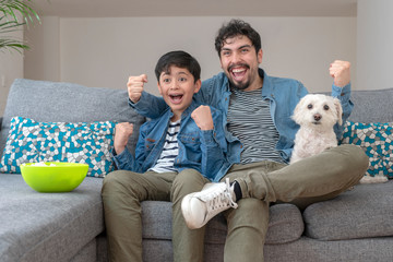 FAMILIA Y PERRO VIENDO JUNTOS TV EN LA SALA