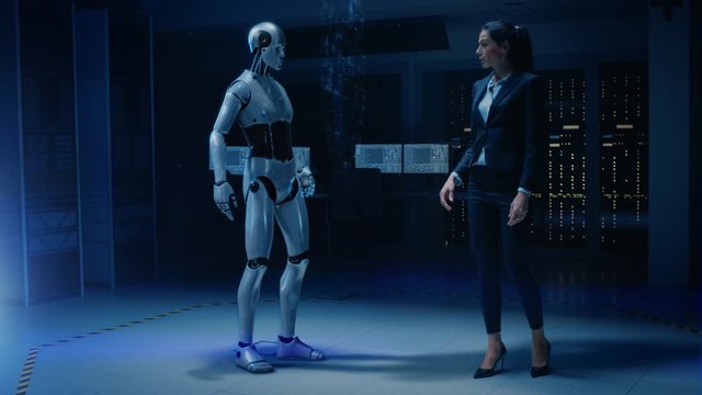 Beautiful, Confident Female Engineer Touching Hands with Humanoid Robot Activating Collaboration, Teamwork Protocol. Computer Artificial Intelligence Concept: People and Robots Working Together