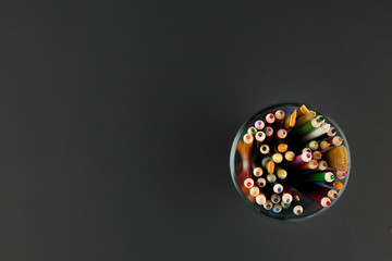 Top view with copy space. Coloured pencils on black background. Concept of Art, Advertisment template, comcept of creative education.