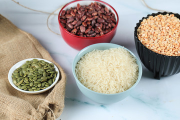 Red beans, rice and peas in colorful bowles on a piece of marble