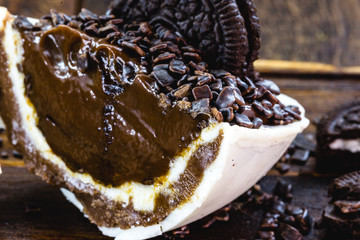 easter 2020 brazil. White chocolate Easter egg with filling, cut in half. Spoon egg. Rustic wood background