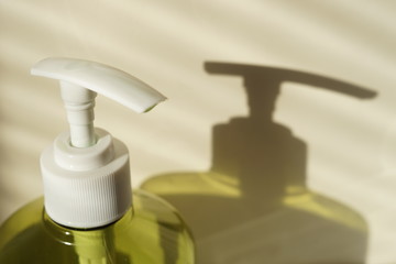 Fototapeta na wymiar Green bottle of liquid soap with a white dispenser.