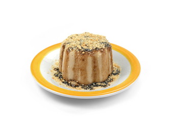 Hazelnut caramel pudding sprinkled with ground biscuits isolated on white background.