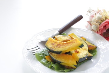 Pan fried pumplin slices on white dish