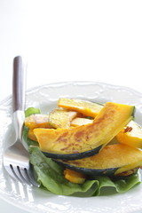 Pan fried pumplin slices on white dish