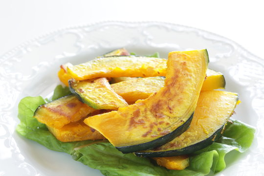 Pan fried pumplin slices on white dish