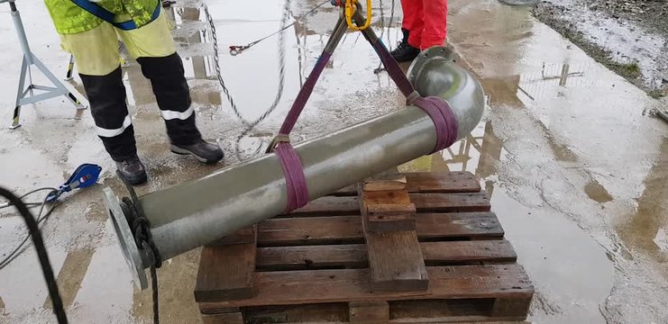 Riggers move the pipe using two chain blocks