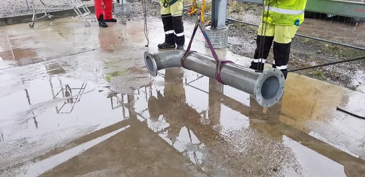 Riggers move the pipe using two chain blocks