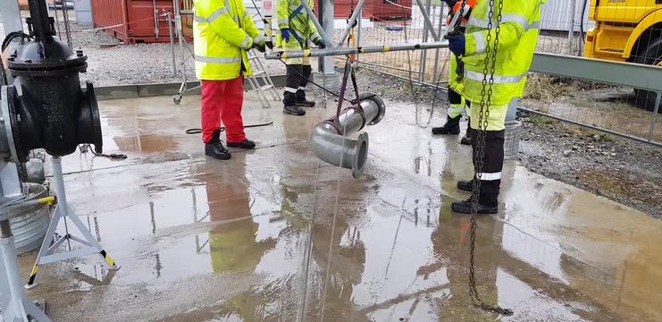 Riggers move the pipe using two chain blocks