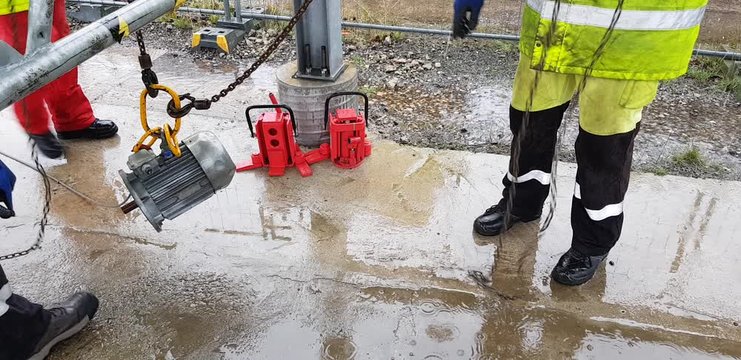 Riggers move the motor using two chain blocks