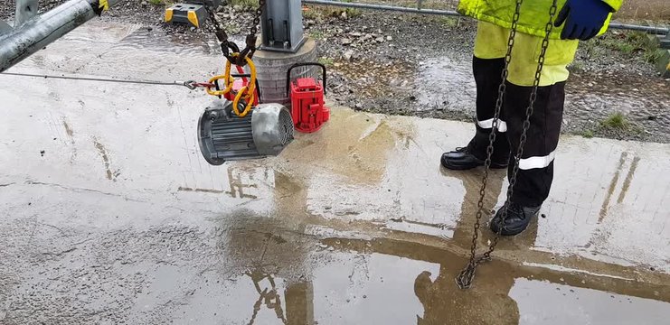 Riggers move the motor using two chain blocks