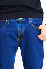 Male model in blue jeans bottom on white background.