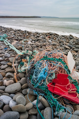 Fototapeta na wymiar Old fishing nets and plastic waste washed up on the shore of the west coast of Ireland