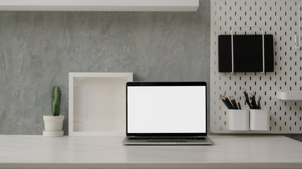 Close up view of modern workspace with blank screen laptop, decorations and copy space