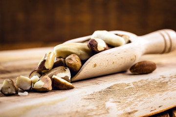 Chocolate egg with filling for Easter on wooden background. Selective focus, wooden background. Easter 2020.kitchen spoon to measure ingredients, rustic wooden spoon, with brazil nuts.