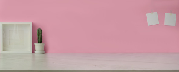 Close up view of feminine workspace with copy space, frame and cactus pot