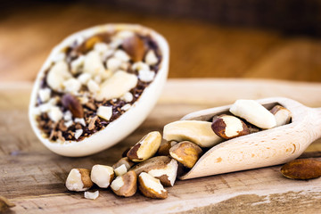 Chocolate egg with filling for Easter on wooden background. Selective focus, wooden background. Easter 2020.kitchen spoon to measure ingredients, rustic wooden spoon, with brazil nuts.