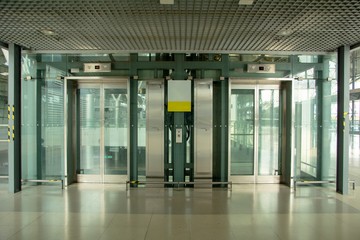 Modern transparent elevator in underground passage © Paisan