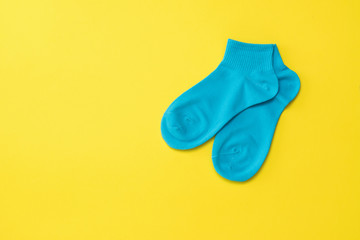 Blue sports socks on a bright yellow background. Flat lay.