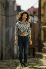 Young asian woman is posing for photo shoot in the old downtown, Porto, Portugal. Beautiful cheerful multicultural female.