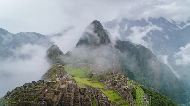 Time lapse view of mysterious Inca ruins of Machu Picchu shrouded in mist high in the Andes mountain range, Cusco Region, Peru.