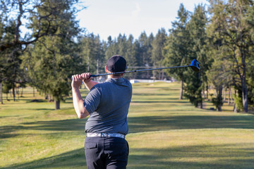 Golfer teeing off on a golf course