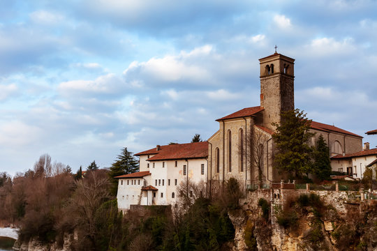 Chiesa e abitazione a dirupo sul fiume Natisone a Cividale del Friuli, Udine, Italia. Nuvolosa giornata con vegetazione spontanea.