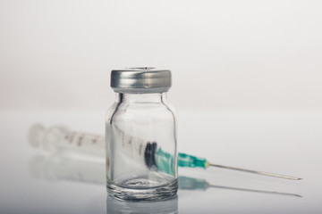 Empty medical vial with syringe and needle on white background.Dramatic color tone