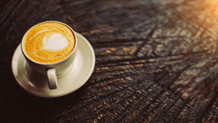 Cup of hot cappucino on the wooden table. Early morning breakfast