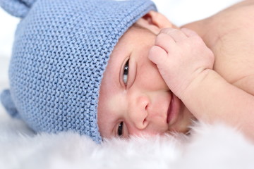 Bebé recién nacido despierto sonriendo con gorro