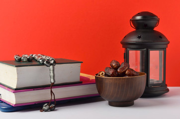 Lantern, dates fruit and rosary on red background. Islamic holidays concept.