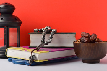 Lantern, dates fruit and rosary on red background. Islamic holidays concept.