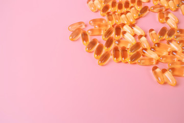 Omega-3 Rich Fish Oil Transparent Capsules Closeup Photo on pink background.